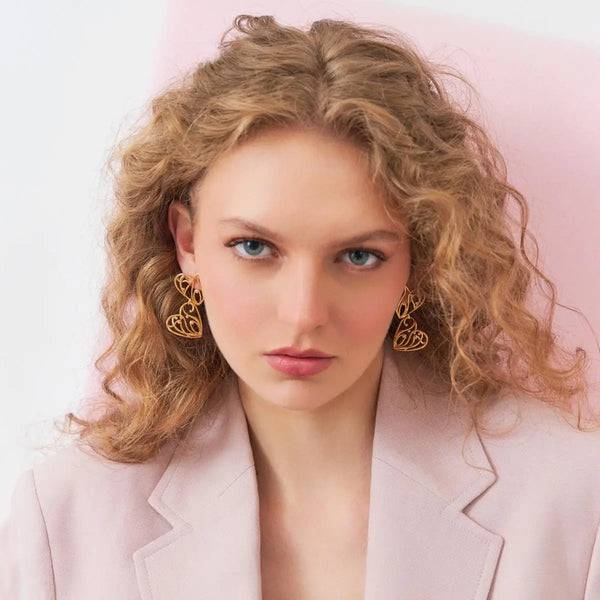 BRINCO PÊNDULO DE CORAÇÕES VAZADOS E ZIRCÔNIAS BANHADO A OURO